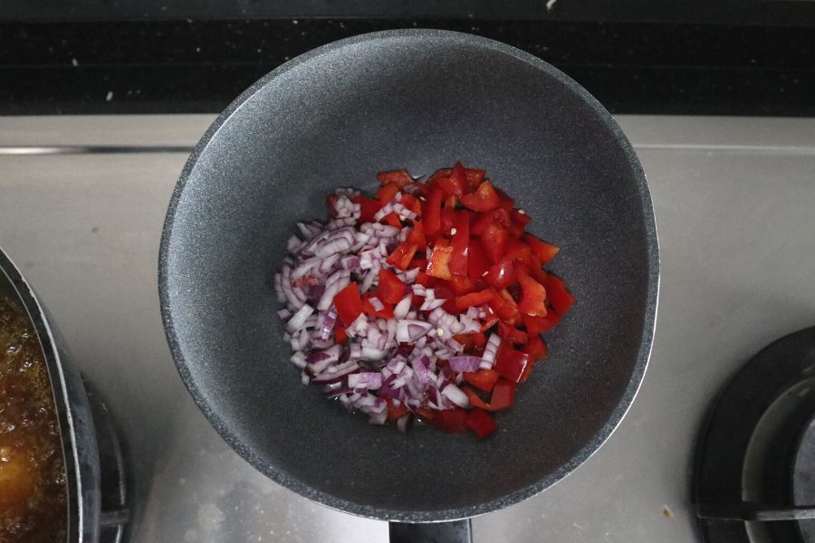 a wok mixed with diced onion and bell pepper